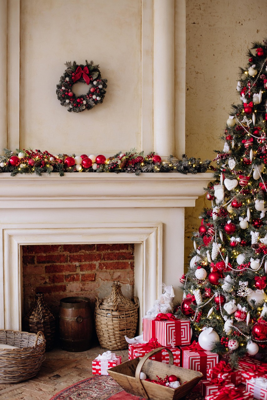 a scene in front of a fireplace (with pine garlands on the shelf above the fireplace), a decorated evergreen tree, and piles of wrapped gifts.